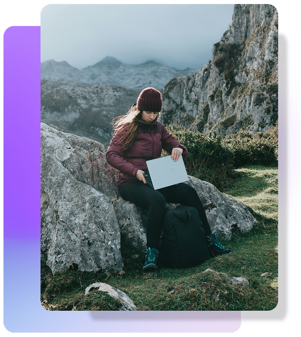 A woman on a mountain top opening her computer. A woman on a mountain top opening her computer.
